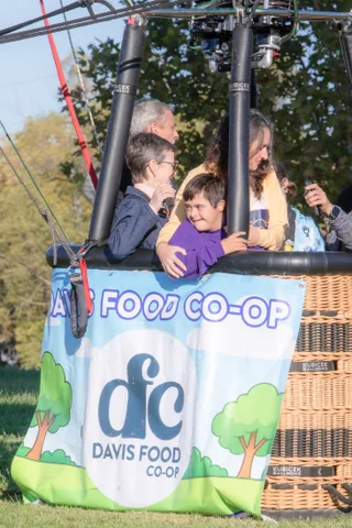 Passengers ride in a basket draped with a sponsor banner