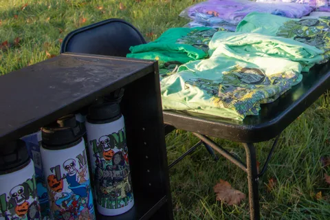 Shirts and bottles laid out on the merchandise table