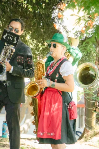 Two band members in costume stand together with a saxophone and a tuba.