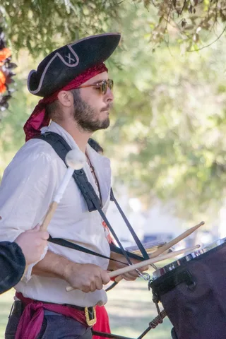 A drummer in a pirate hat and sash keeps time with the band.