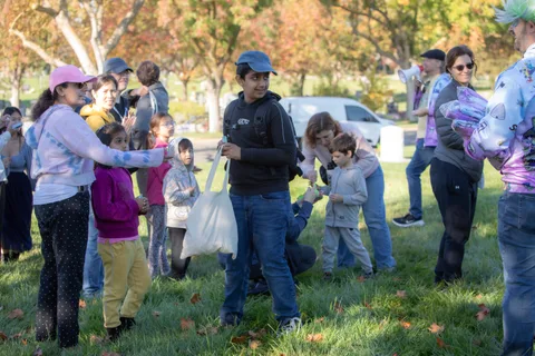 People gather on the grass handing out bags