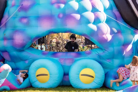 An attendant looks out through the opening of the octopus bounce house.