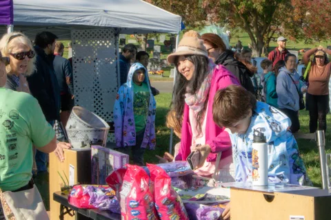 Guests browse merchandise laid out under a canopy