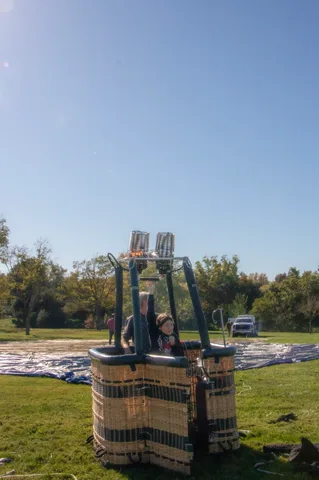 A balloon basket standing upright on its ground tarp