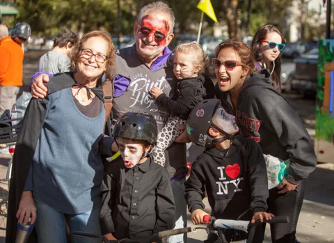 A family group in costume poses together outdoors.