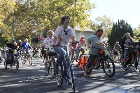 Riders continue along the tree-lined parade route.