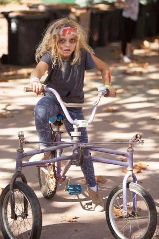 A rider leans over the handlebars of a low custom trike.