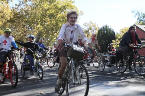 A woman rides her bike along the parade route.