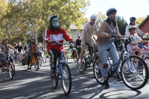 Riders in zombie makeup gather on bikes at the start of the ride.