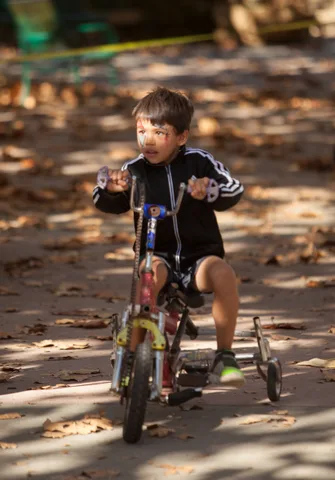 A rider pedals a small trike away from the camera.