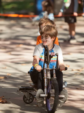 Two boys walk together wearing bead necklaces.