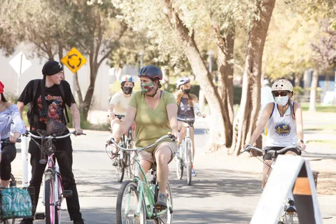 Two riders pedal side by side toward the camera.