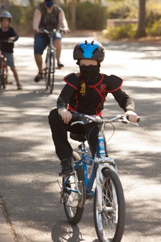 A rider pops a wheelie on a bike down the empty path.