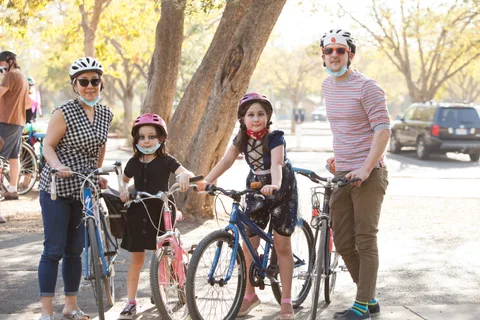 A family in masks poses together in the park.