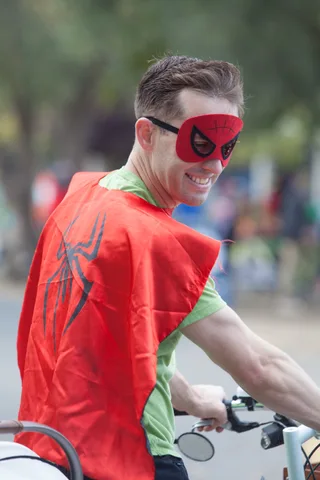 A close crop of a red and green costume sleeve on a bike handlebar.