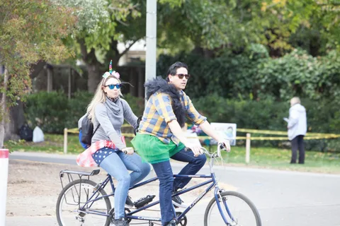 A couple rides bikes together down the path.