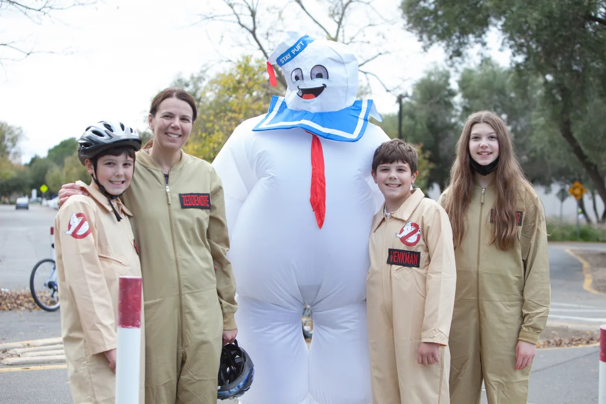 A family dressed as Ghostbusters poses with a giant inflatable Stay Puft Marshmallow Man.