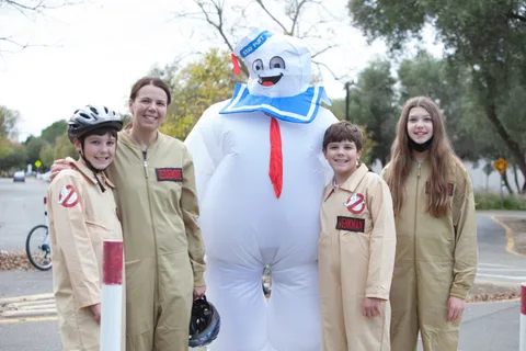 A family dressed as Ghostbusters poses with a giant inflatable Stay Puft Marshmallow Man.