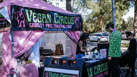 Staff work the counter of the Vegan Circus food booth.