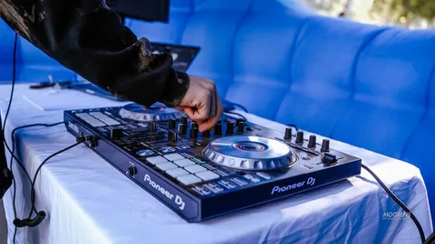A DJ's hands adjust knobs on a mixing board at the festival.