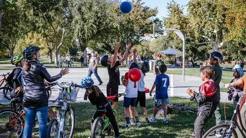 A family plays catch with a ball in the open park.