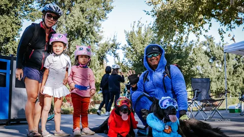 A mother and two young children in helmets pose together at the festival.