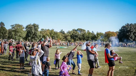 Families cheer and hold children up to watch the finale overhead.