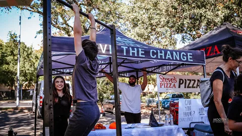 A person demonstrates a pull-up bar exercise at a booth.