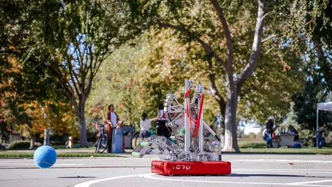 A small competition robot sits on the basketball court.