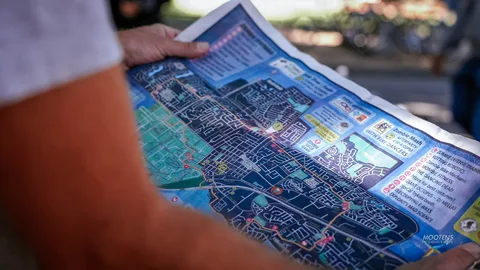 Someone holds up a printed map of the local area.