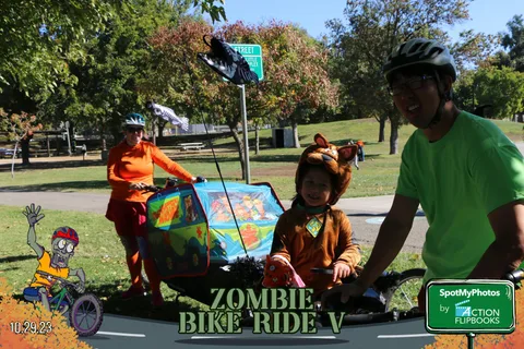 A decorated cargo bike float carries costumed performers through the park.