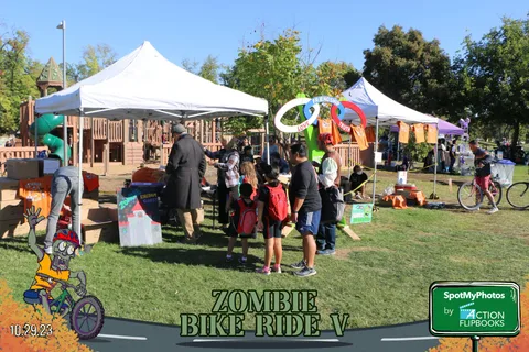 Guests play a ring toss game between festival vendor tents.