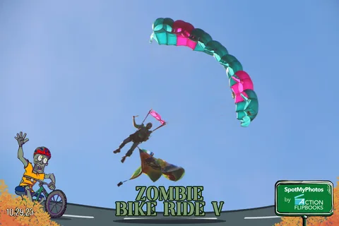 A parachute canopy hangs beneath a skydiver as it descends toward the field.