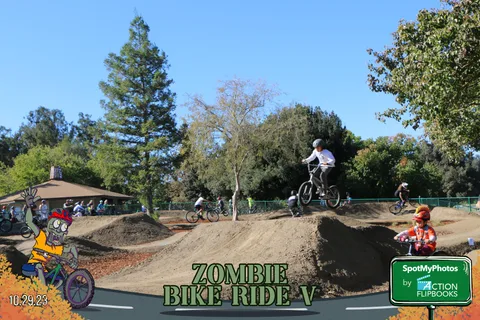 A BMX rider catches air on the dirt jump track.