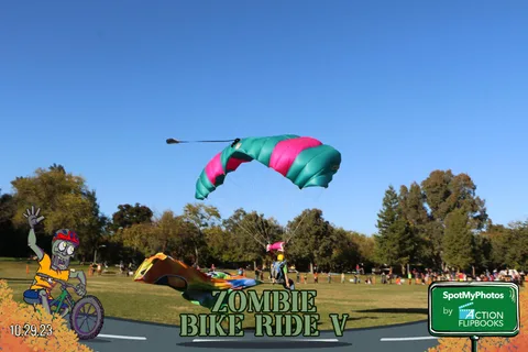 A colorful parachute descends against a clear blue sky mid-flight.
