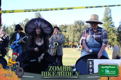 A witch hat guitarist and a saxophone player perform together at the finish line.