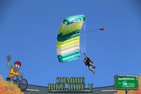 A green and white striped parachute descends against a clear blue sky.