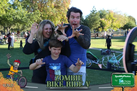 A woman, man and boy make playful scary faces at the camera.