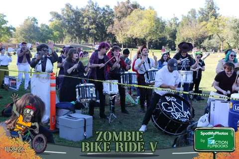 Costumed drummers play together in a row as festival-goers gather nearby.