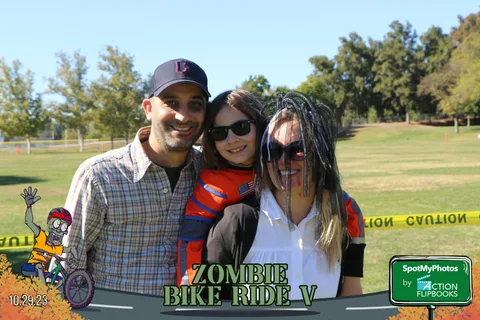 A man, a face-painted girl and a woman pose together casually.