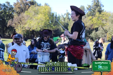 A pirate-costumed drummer performs with a band at the finish line.