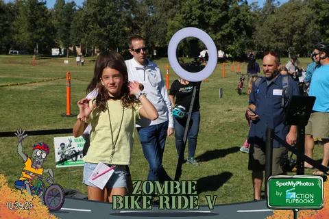 A girl poses for the camera near festival photo booth gear.