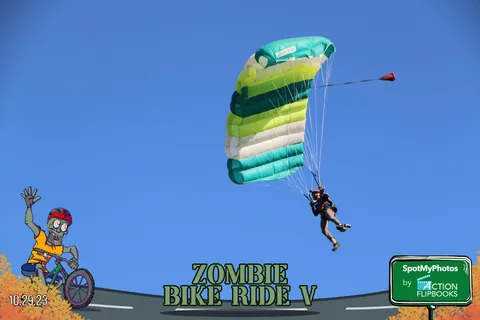 A green and yellow striped parachute descends against a clear blue sky.