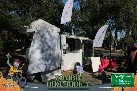 An empty vendor booth display case is set up on the grass before the crowd arrives.