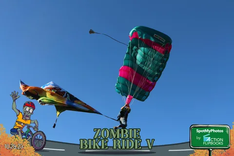 Two parachutists fly close together against a clear sky with pink smoke.