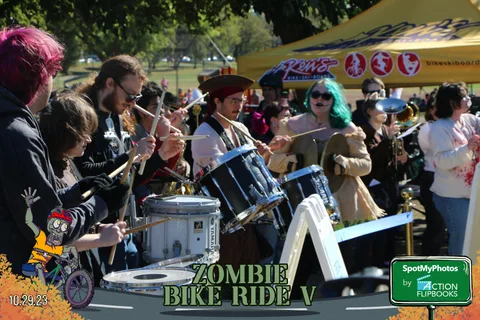 Costumed drummers perform near a festival vendor tent.