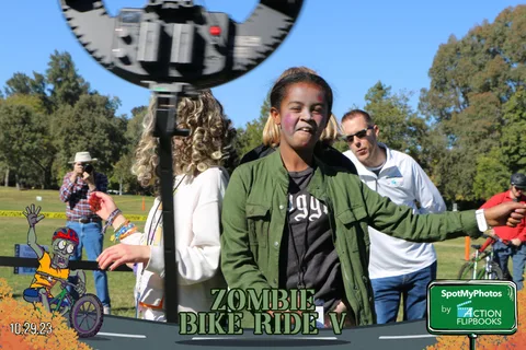 A woman in a green jacket smiles closely at the camera.