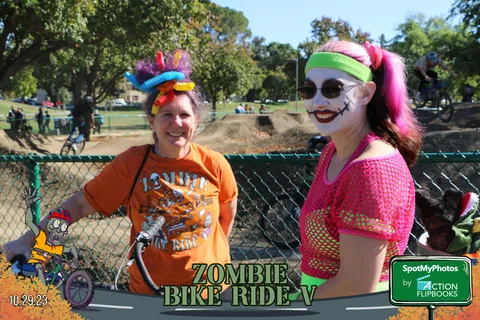 Two women in elaborate costume headdresses and makeup pose together.