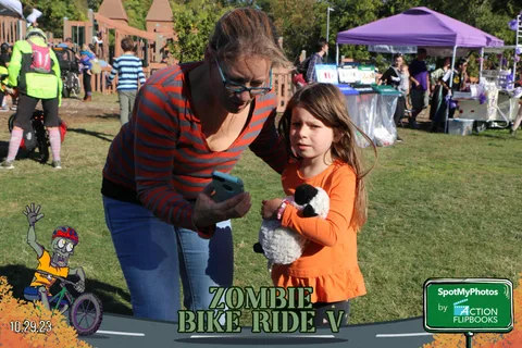 A woman and a young girl in orange share a close moment at the festival.