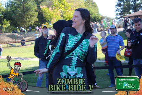 Two friends in glow-in-the-dark skeleton bodysuits embrace and smile at the finish line.